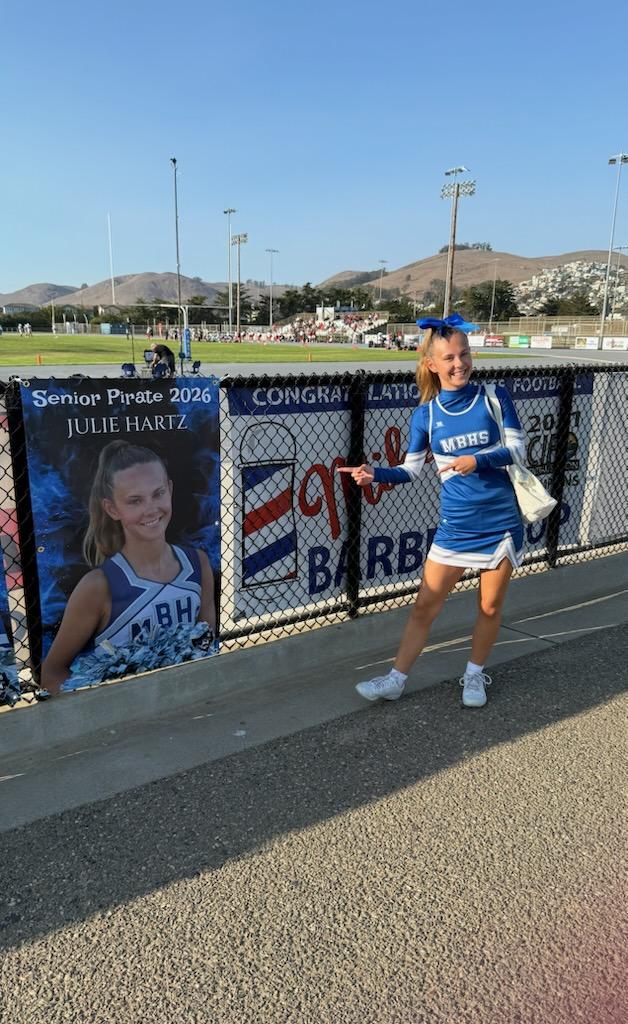Julie Hartz looking at her senior cheer poster 
