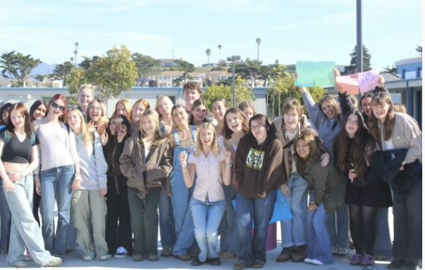 Protest attendees pose for a group photo, senior class president Lucy Fortini sitting front and center. (Shot by Emerson Jacquay)