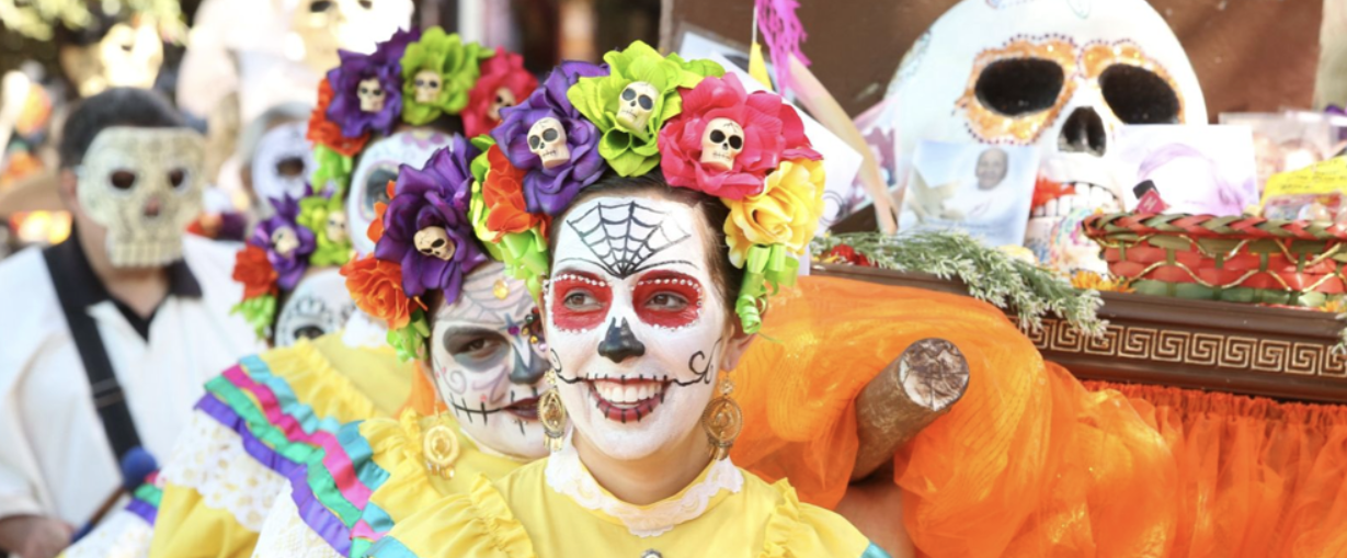 This picture shows people celebrating Dia de los Muertos with colorful face paint and traditional costumes. (Photo credit: City of San Antonio)