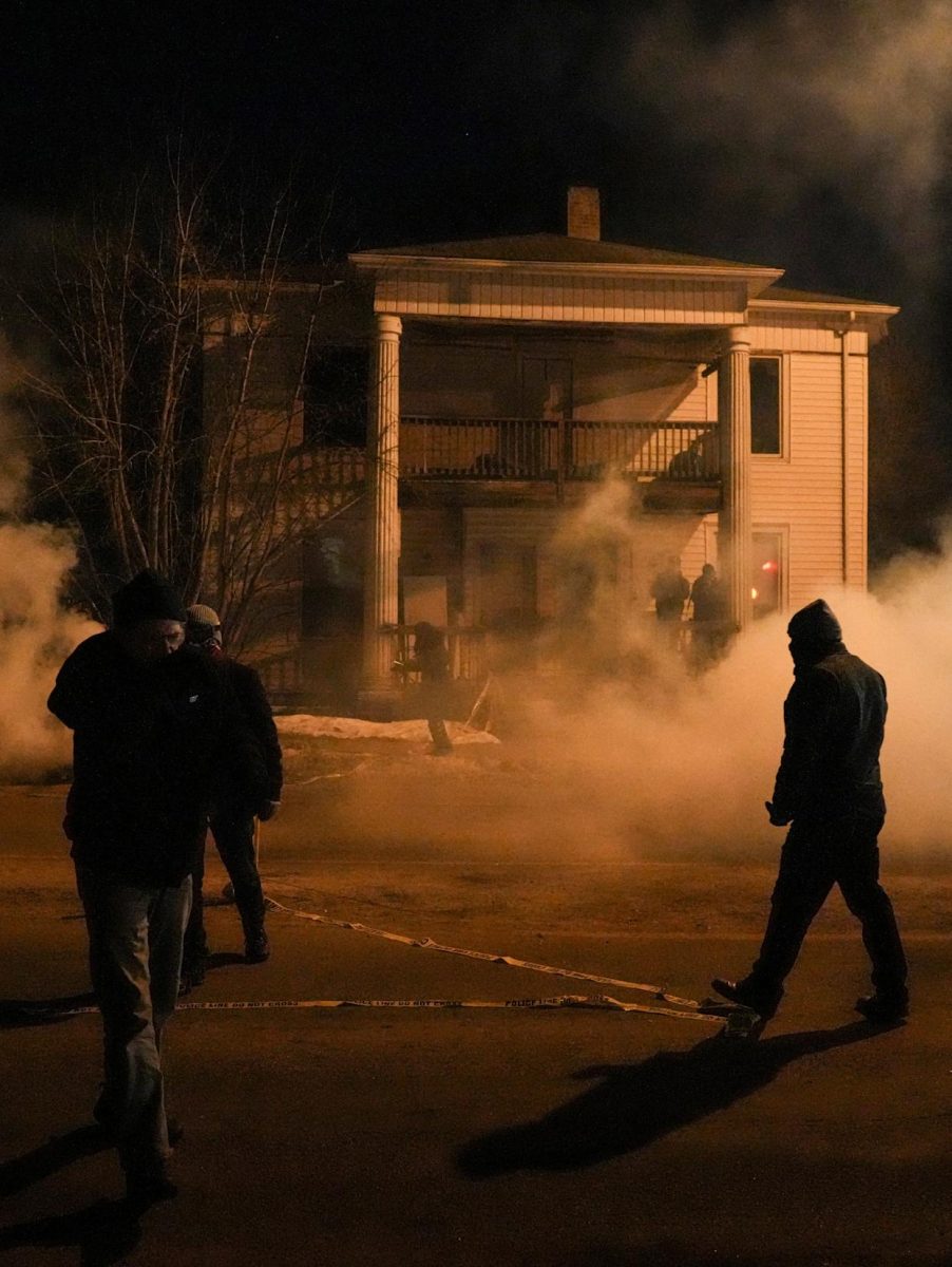 Members of North Minneapolis community stand outside a building amidst tear gas used by federal agents. (Source: AOL)