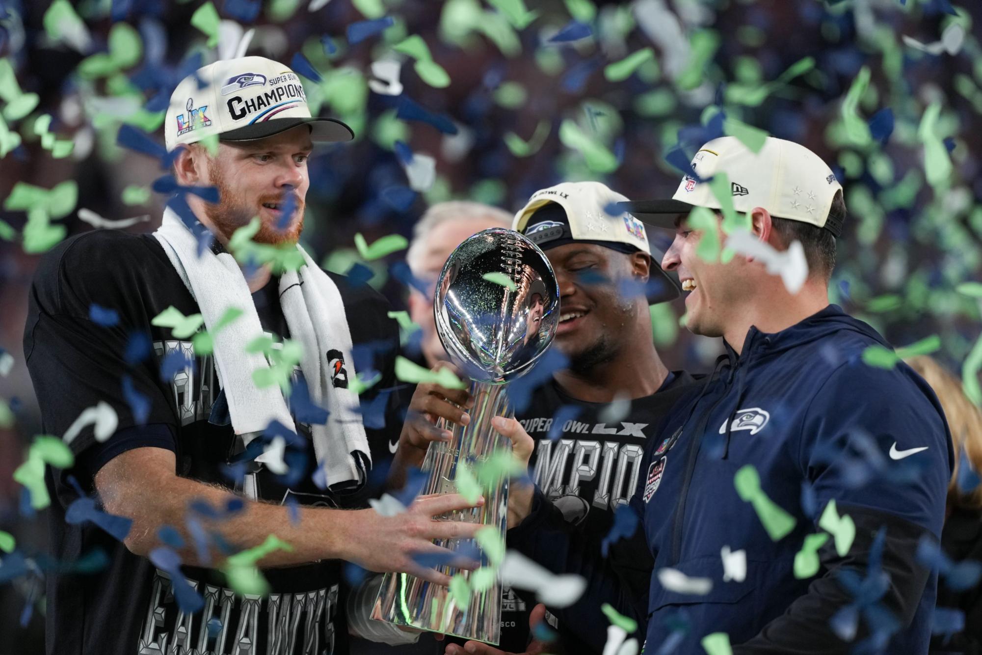 Seattle Seahawks quarterback Sam Darnold, running back Kenneth Walker III, and head coach Mike Macdonald hold the Lombardi Trophy after winning Super Bowl LX on Sunday, February 8.
