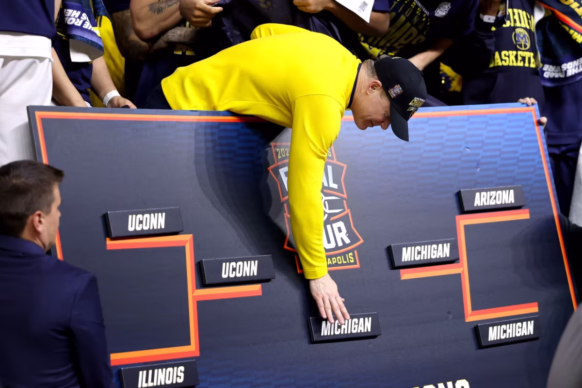 Head Coach Dusty May places Michigan in the bracket while celebrating post-game.