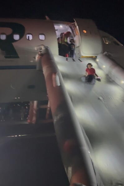 Passengers evacuated the plane on an emergency slide (Source: AP News)